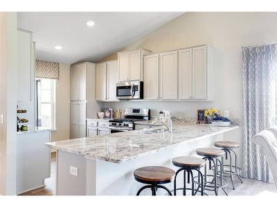 A stunning kitchen layout, all while remaining remarkably functional: The counters are endless, the sink is under-mounted, the range is gas and the microwave is vented to the exterior of the home. Photo of model home, colors will vary. | Image 3