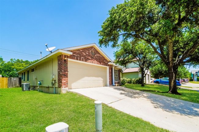 Ranch-style home with brick siding, an attached garage, and driveway | Image 4