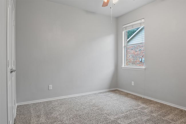 Empty room with a ceiling fan, carpet flooring, and baseboards | Image 33