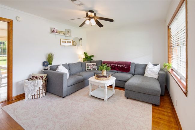 Living area featuring wood finished floors, ceiling fan, baseboards, and crown molding | Image 5