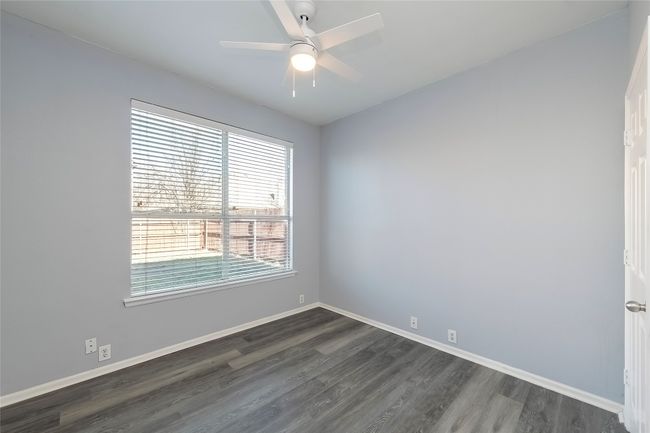 Empty room with dark wood-style floors, baseboards, and a ceiling fan | Image 27