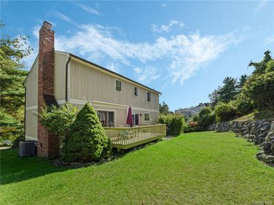 Rear view of house featuring central AC unit, a yard, and a wooden deck | Image 2