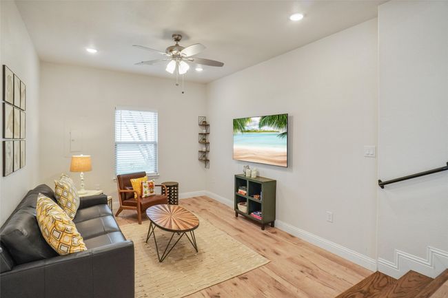 Living room with ceiling fan and light wood-type flooring | Image 12