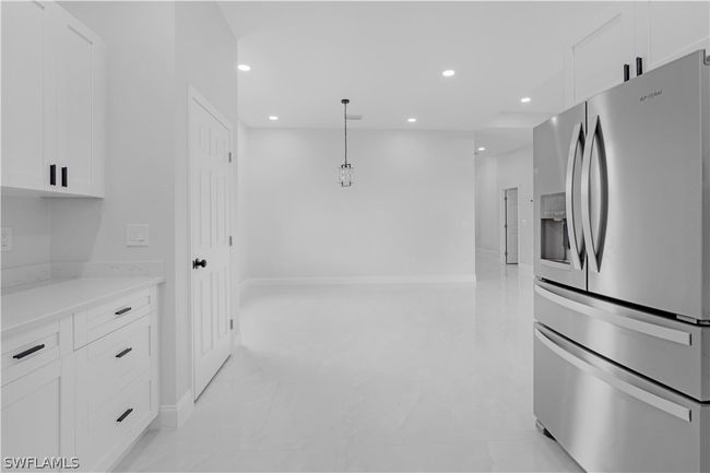 Kitchen featuring stainless steel refrigerator with ice dispenser and white cabinetry | Image 36