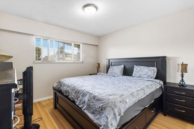 Bedroom with light wood-style floors, baseboards, and a textured ceiling | Image 16