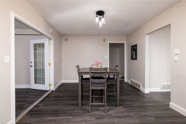 Dining space featuring visible vents, baseboards, and wood finished floors | Image 9