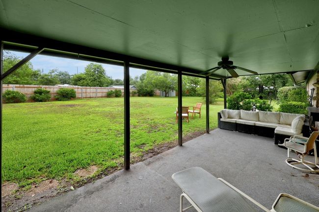 Fenced backyard with an outdoor living space, a patio area, and ceiling fan | Image 27