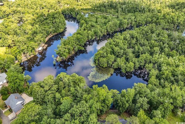 Drone / aerial view of a nearby body of water and a heavily wooded area | Image 35