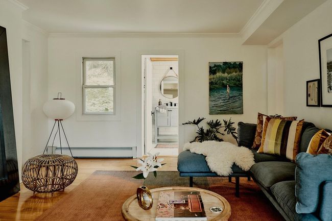 Living area with a baseboard heating unit, wood finished floors, and ornamental molding | Image 16