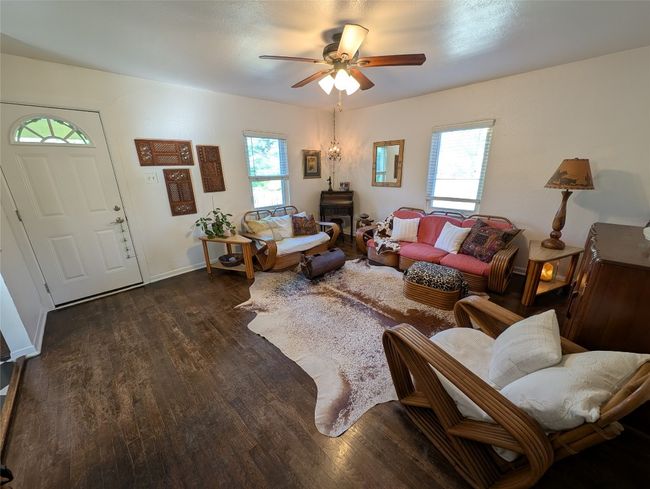 Living area featuring 1960's dark hardwood floors, and ceiling fan | Image 7