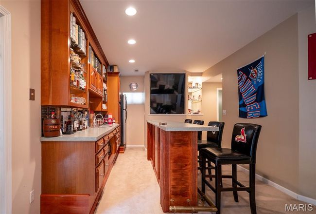 Indoor dry bar with light colored carpet and recessed lighting | Image 48