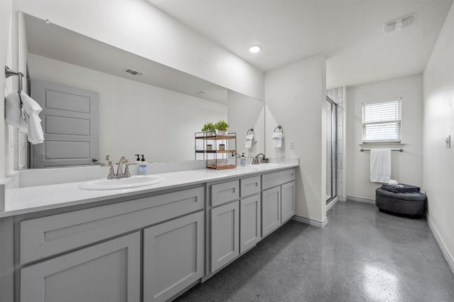 Bathroom with concrete floors, a sink, double vanity, and baseboards | Image 13
