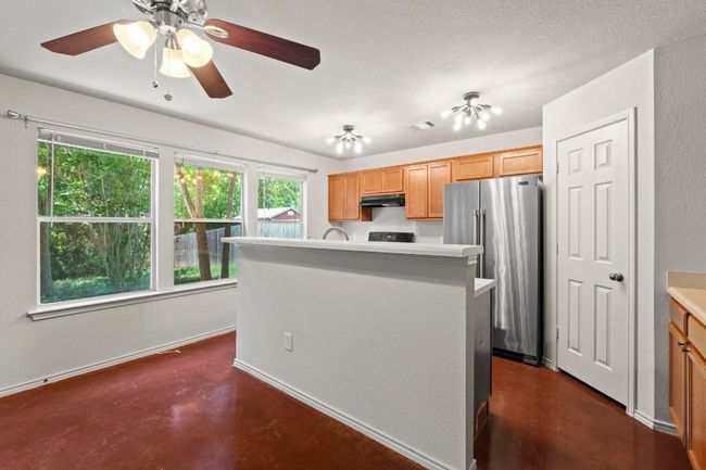 Charming light fixtures and a wall of windows brighten up the kitchen. | Image 9