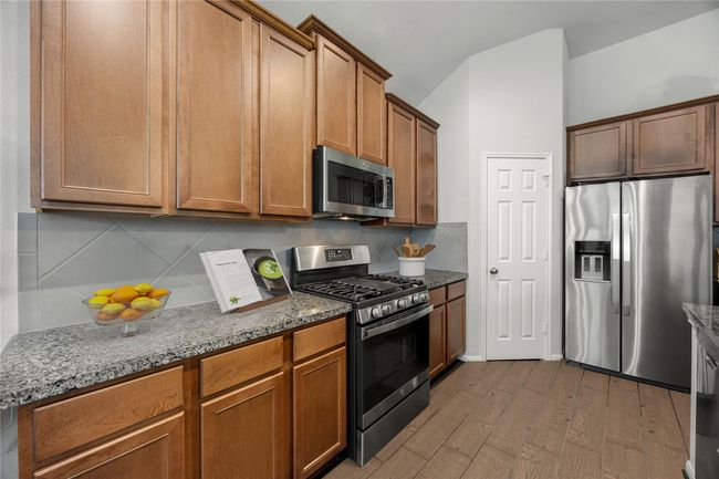 Enjoy the beauty and function of this modern kitchen, complete with a gas range stove, granite surfaces, and an open layout made for entertaining. *Virtually Staged | Image 10