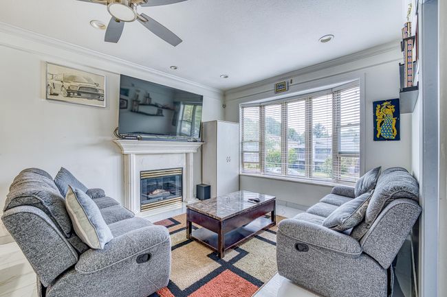 Living room with ceiling fan, ornamental molding, a premium fireplace, and recessed lighting | Image 7