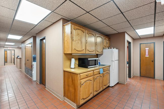 Kitchen with stainless steel microwave, freestanding refrigerator with tile patterned flooring | Image 34