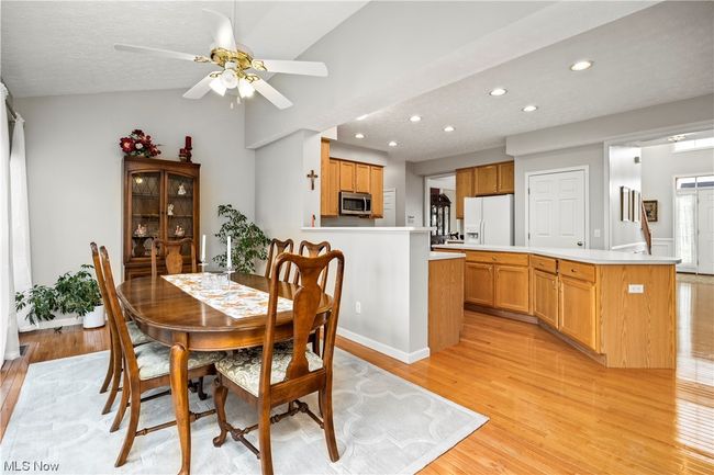 Dining room featuring vaulted ceiling, light wood-type flooring, and ceiling fan | Image 13