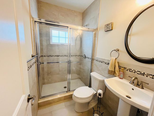 Full bath featuring tile walls, a shower stall, and tile patterned flooring | Image 10