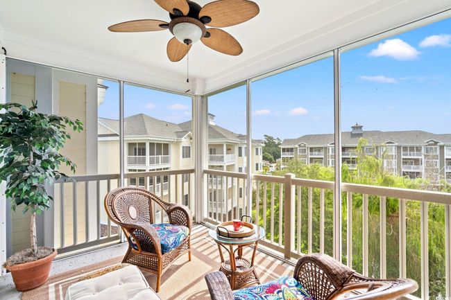 Sunroom / solarium with a residential view and a ceiling fan | Image 5
