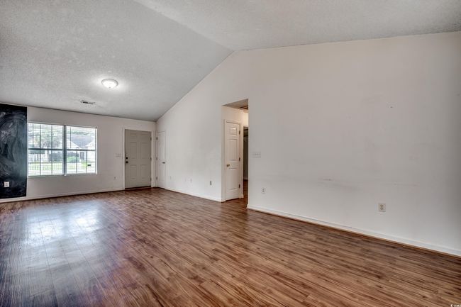 Unfurnished room featuring vaulted ceiling and wood finished floors | Image 21