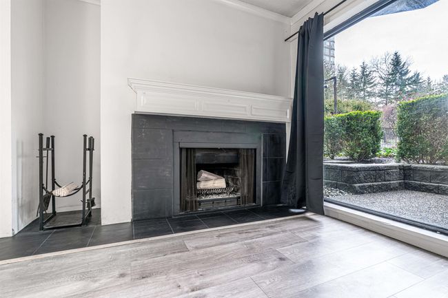 Room details featuring wood finished floors, a fireplace, and ornamental molding | Image 11