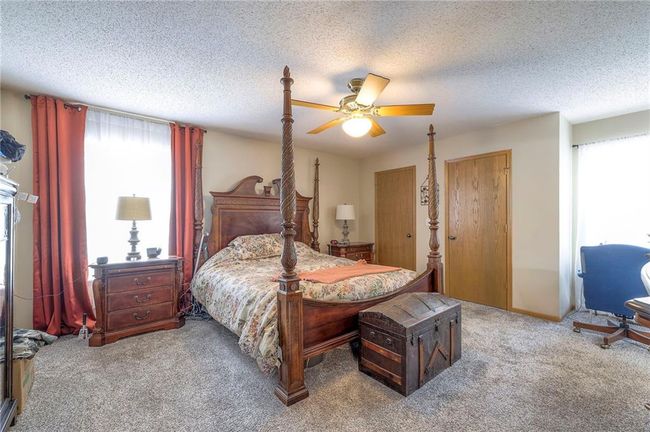Bedroom featuring carpet, a textured ceiling, and a ceiling fan | Image 17