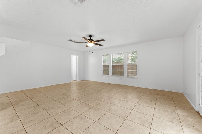 Unfurnished room featuring light tile patterned flooring, ceiling fan, and a textured ceiling | Image 10