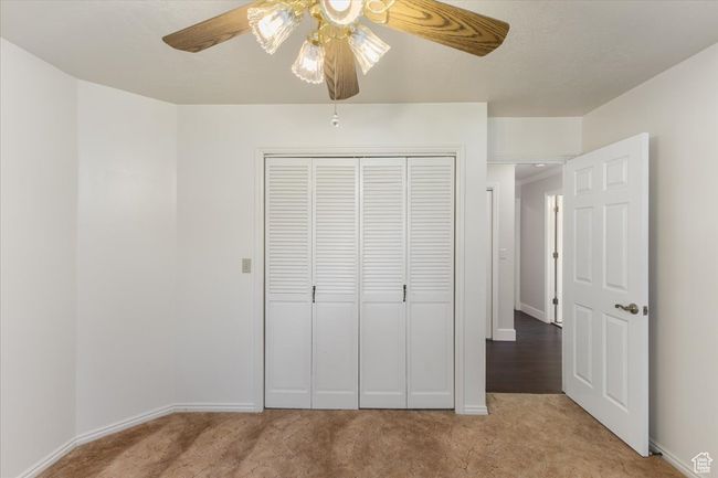 Unfurnished bedroom featuring a closet, baseboards, ceiling fan, and light colored carpet | Image 17