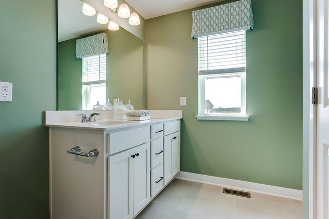 The primary bedroom's private bath. 2 sinks, a shower, and ample space to share! Photo of model home, colors and selections shown may vary | Image 11