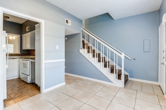 Staircase featuring tile patterned floors and a textured ceiling | Image 5