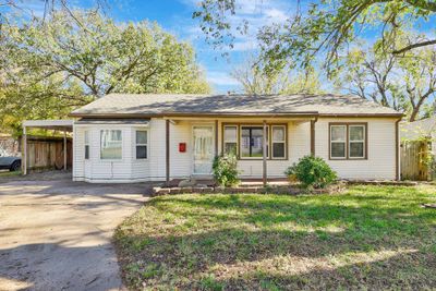 Ranch-style house with a carport, a front lawn, and covered porch | Image 1