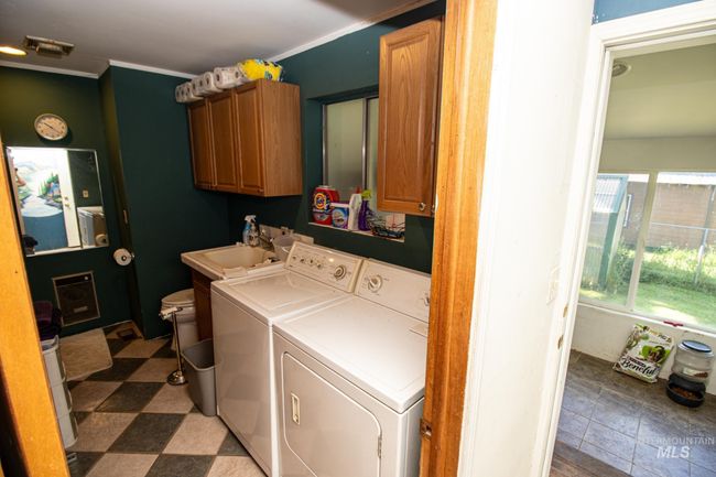 Laundry room featuring washing machine and dryer, cabinet space, and crown molding | Image 28
