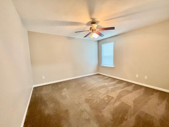 The second guest bedroom is large with ceiling fan | Image 15