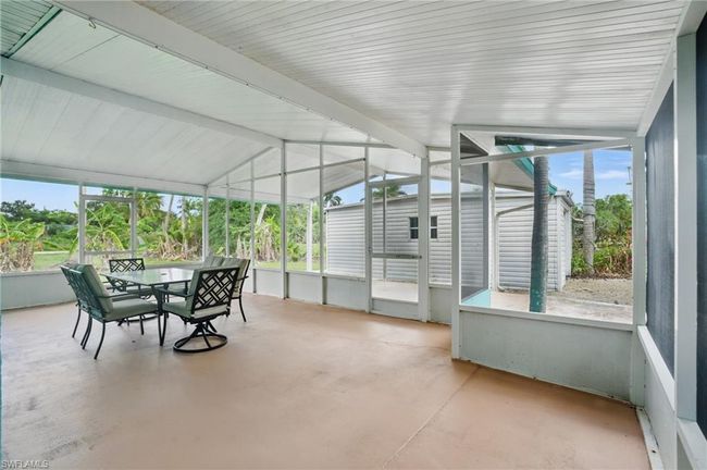 Sunroom / solarium featuring outdoor dining area, vaulted ceiling, and plenty of natural light | Image 9