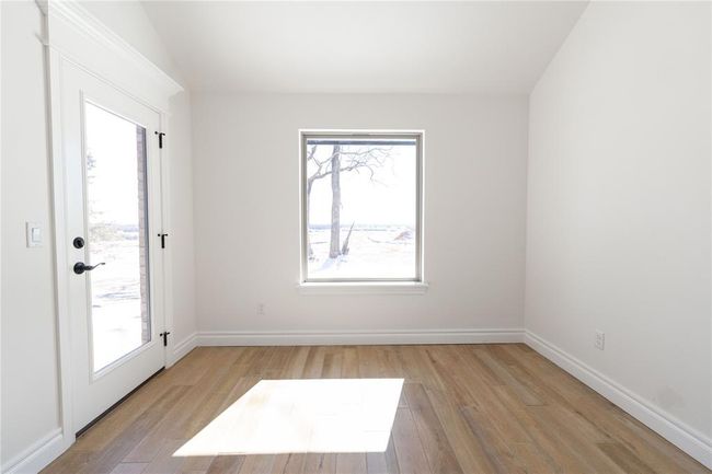 Carpeted empty room with a wealth of natural light, a ceiling fan, baseboards, and lofted ceiling | Image 7