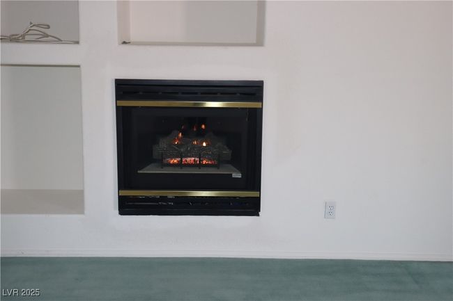 Detailed view of a lit fireplace and baseboards | Image 44