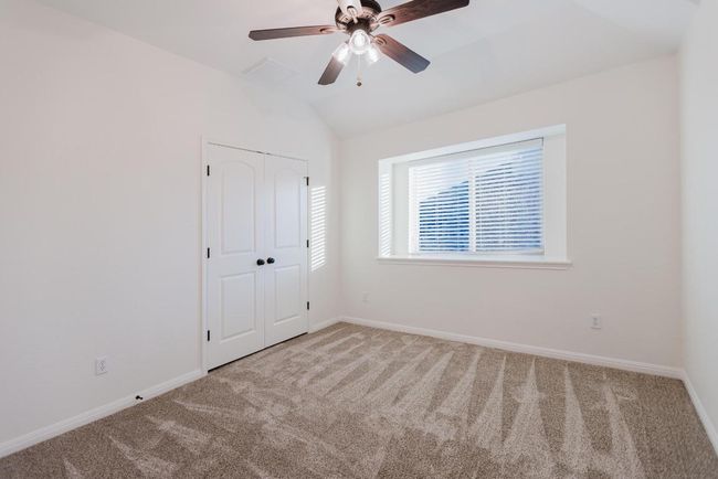upstairs bedroom 2 with lofted ceiling, carpet flooring, baseboards, and a closet | Image 25
