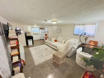 Carpeted living room with a textured ceiling | Image 2