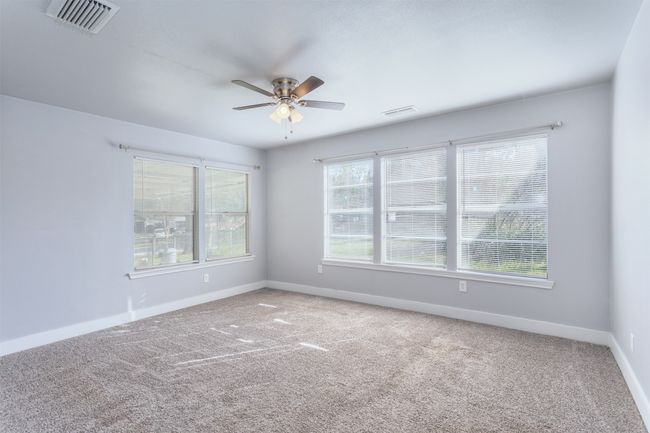 Spare room featuring baseboards, a ceiling fan, visible vents, and carpet floors | Image 13