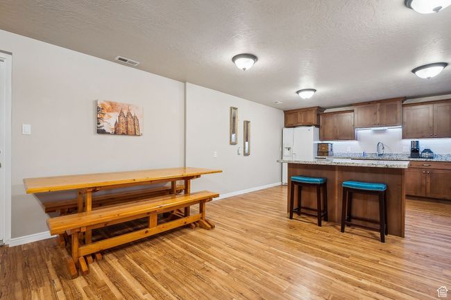 Kitchen featuring a kitchen island, baseboards, visible vents, and light wood-style flooring | Image 44