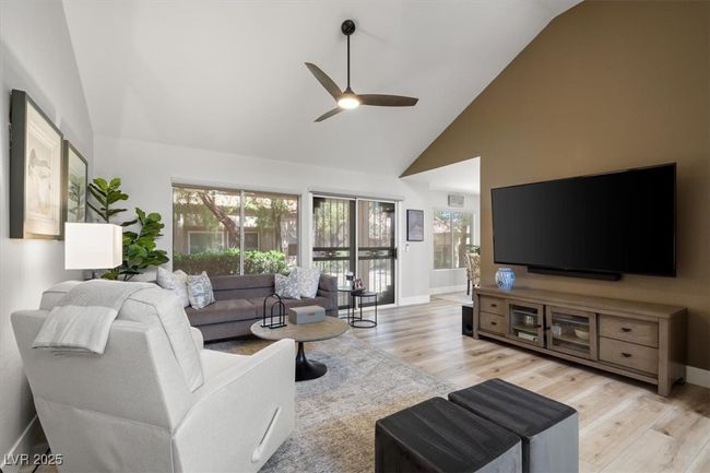 Inside you'll discover soaring majestic ceilings, an open-concept floor plan, sleek pocket windows, & warm natural light. The upgraded interior features luxury flooring, fresh designer paint, & new baseboards. Relax by the linear fireplace or entertain in the formal dining area. | Image 13