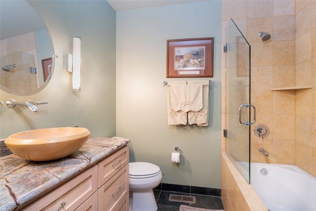 Full bathroom featuring toilet, enclosed tub / shower combo, tile patterned flooring, and vanity | Image 27
