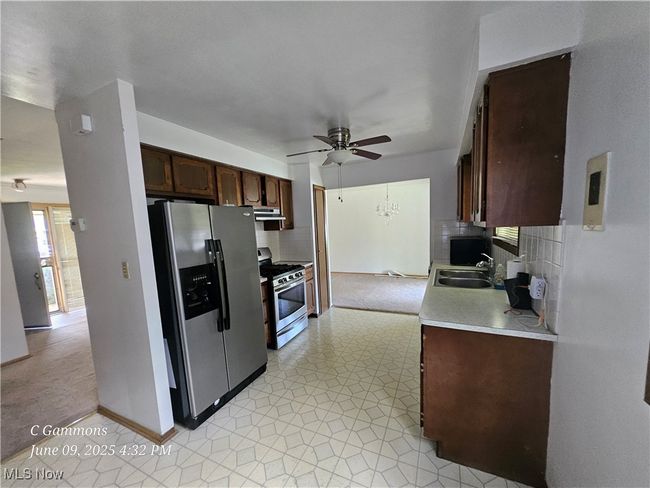 Kitchen featuring appliances with stainless steel finishes, a ceiling fan, light countertops, decorative backsplash, and exhaust hood | Image 4