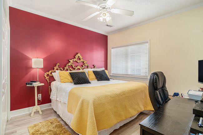 Bedroom featuring wood finished floors, ornamental molding, ceiling fan, and a textured ceiling | Image 15