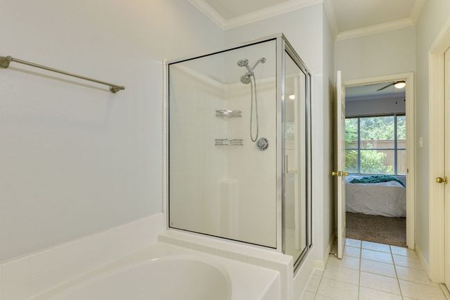 Full bathroom with a shower stall, connected bathroom, ornamental molding, a garden tub, and tile patterned floors | Image 23