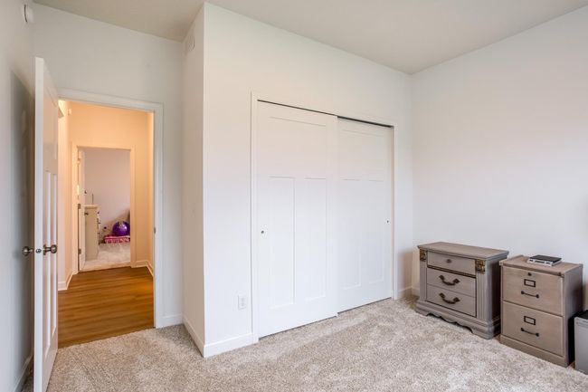 Comfortable secondary bedroom with soft carpeting, ample closet space, and neutral tones throughout. | Image 25