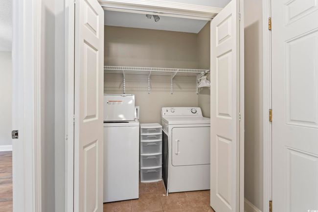 Clothes washing area featuring independent washer and dryer and light tile patterned floors | Image 24
