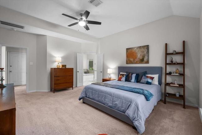 This spacious primary bedroom features a large arched window offering plenty of natural light and views of the lake. | Image 18