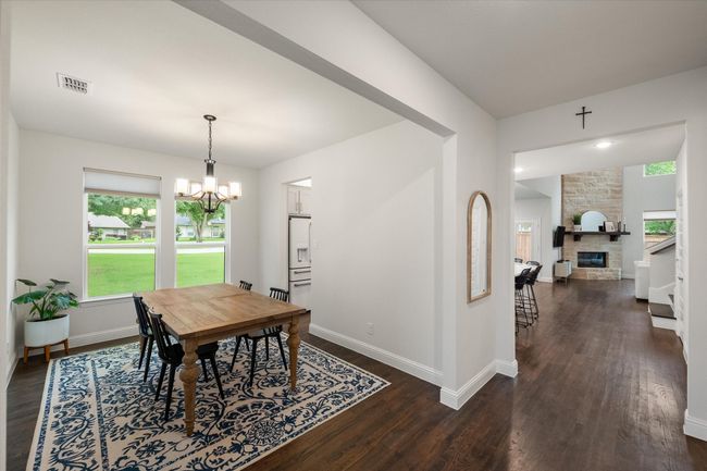 Dining area features a decorative light fixture. | Image 19