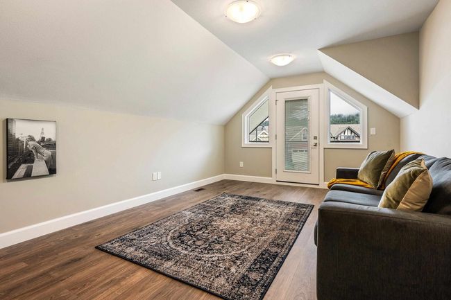 Interior space with dark wood-style floors, vaulted ceiling, visible vents, and baseboards | Image 27